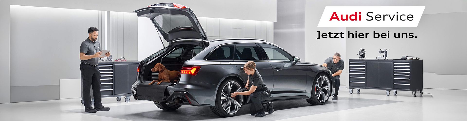 Schwarzer Audi RS 6 Avant in Audi Service-Werkstatt. Drei Personen begutachten das Fahrzeug. Text: "Audi Service. Jetzt neu bei uns."